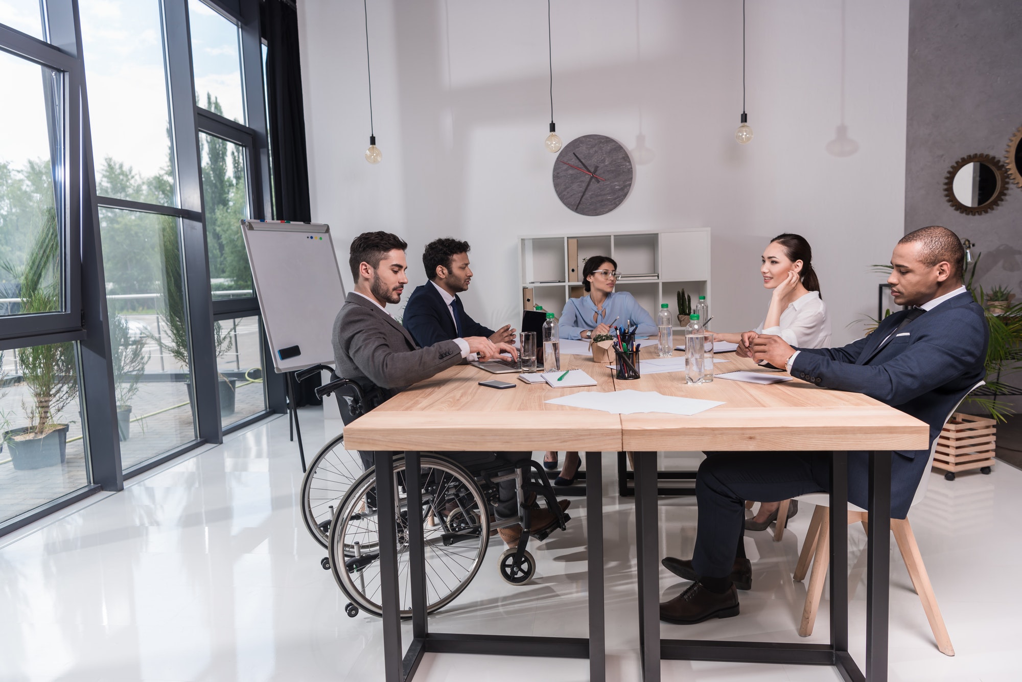 multicultural group of businesspeople discussing new idea while sitting at table in office